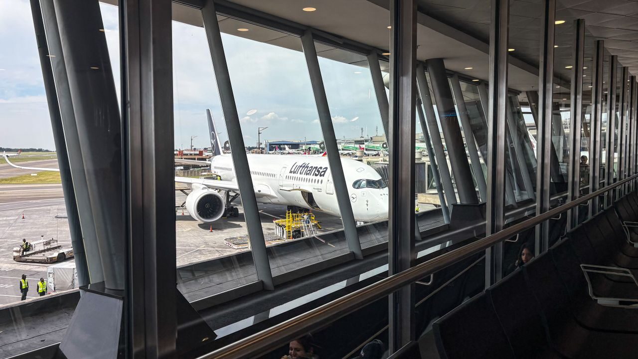 Lufthansa repülőgép a beszállókapunál, a terminál ablakán át nézve